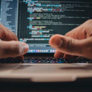 African American man sitting in front of computer coding, programming, web developer