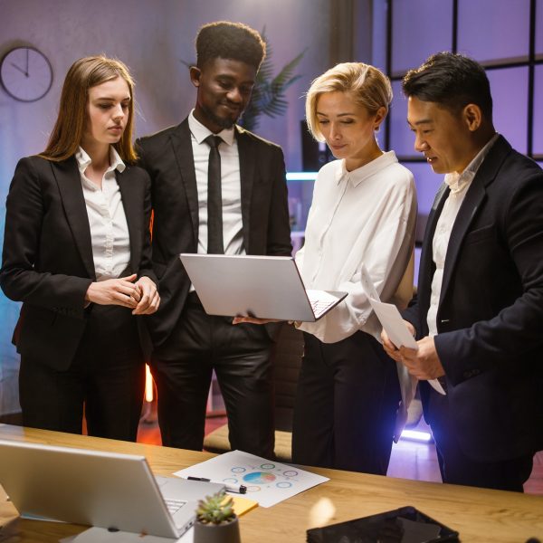 Four colleagues brainstorming at dark office